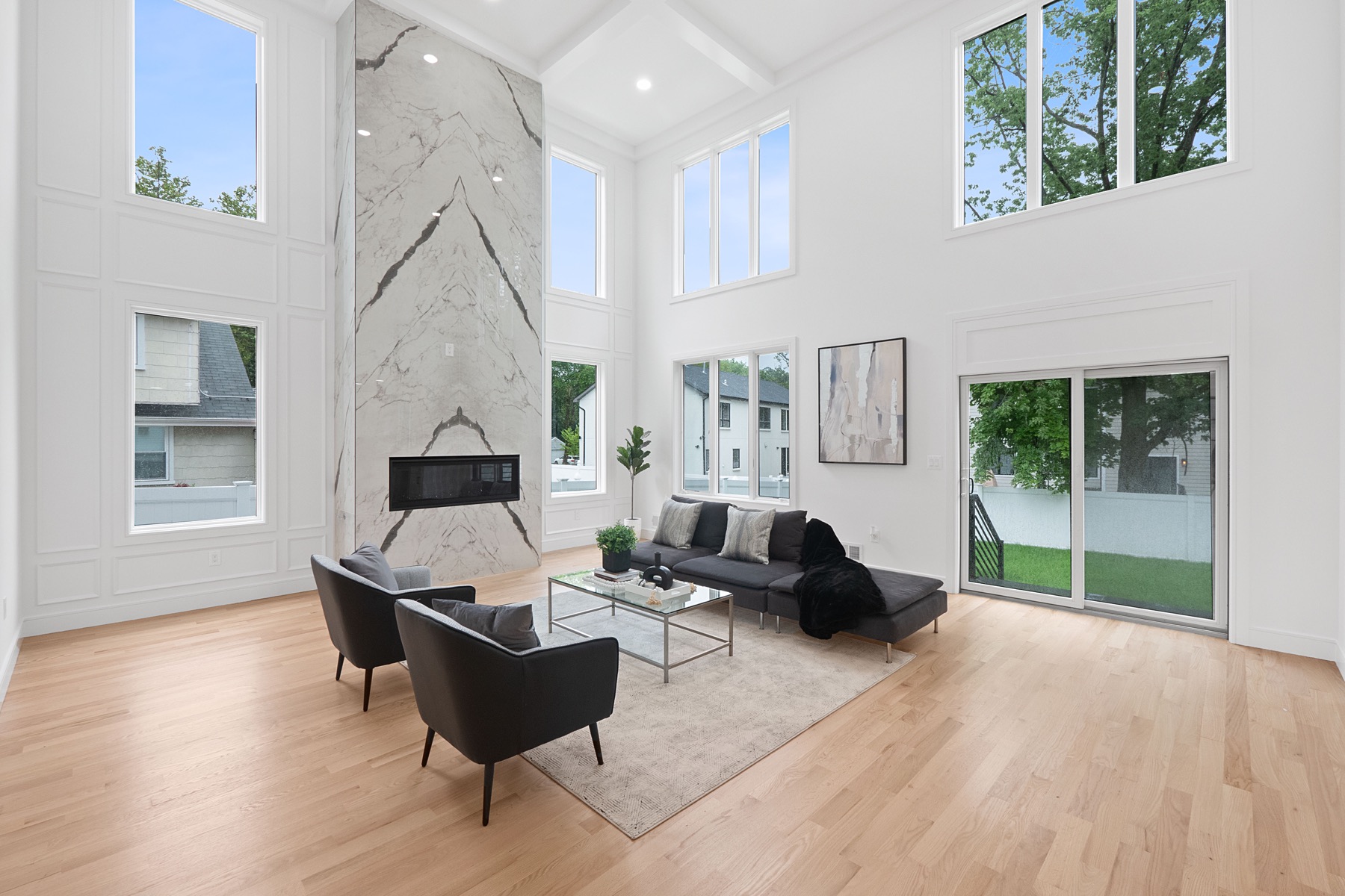 Double-height living room with a marble fireplace